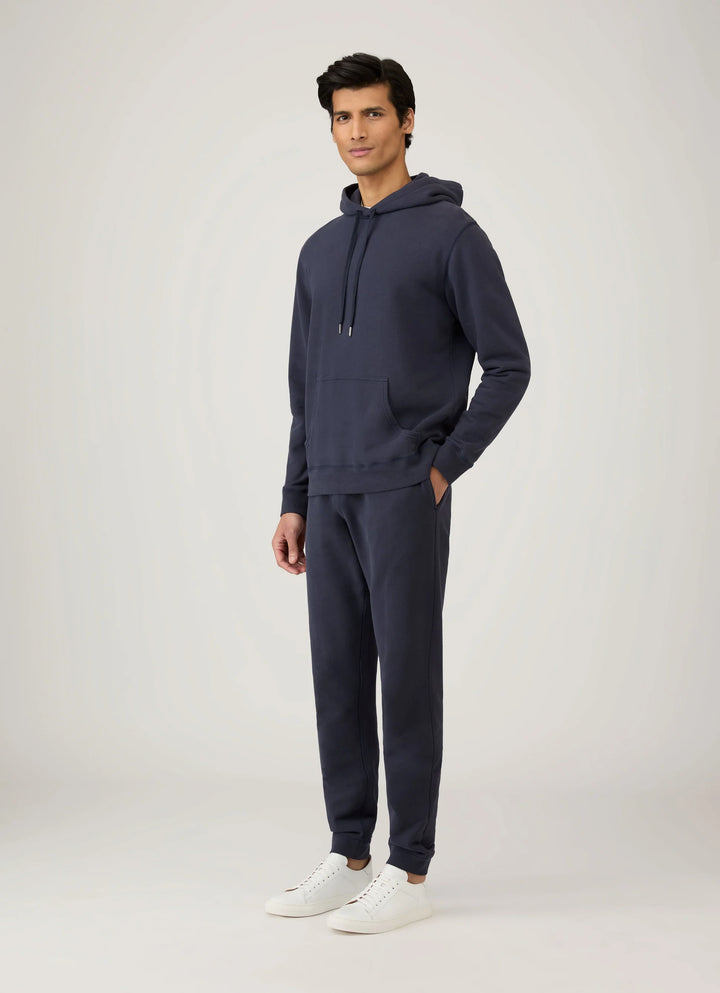 Man wearing a navy hoodie and jogger set on a white background