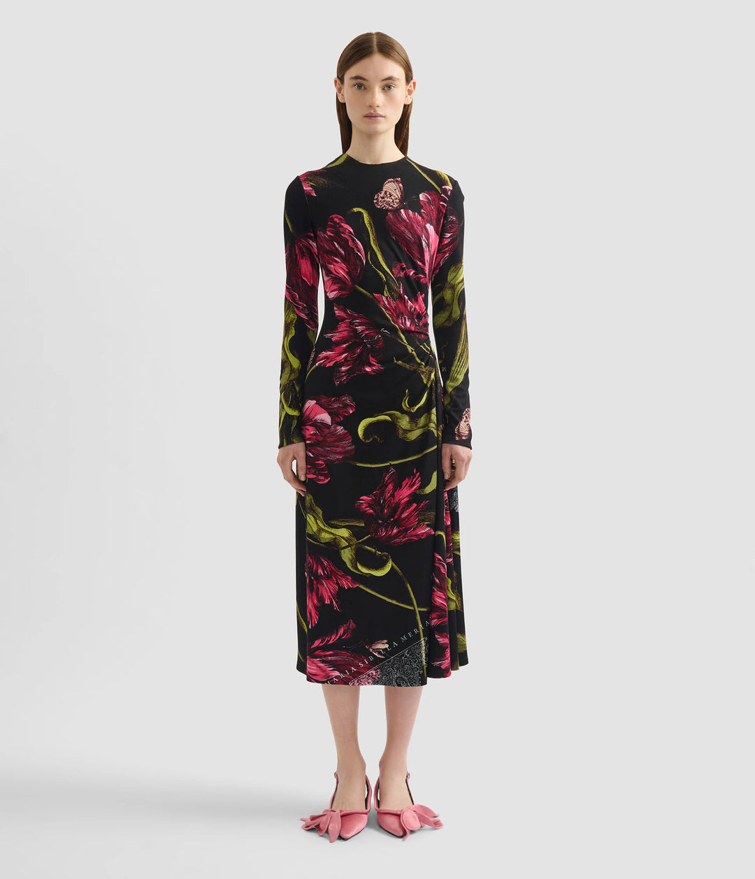 Model wearing a black floral dress on a white background