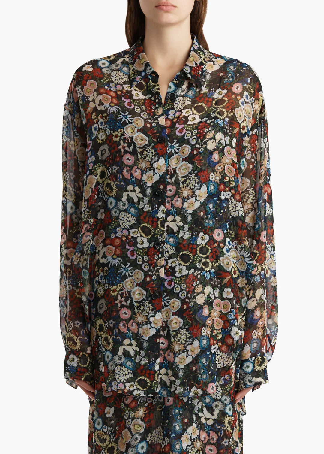Multicolored floral patterned shirt worn by a person on a white background