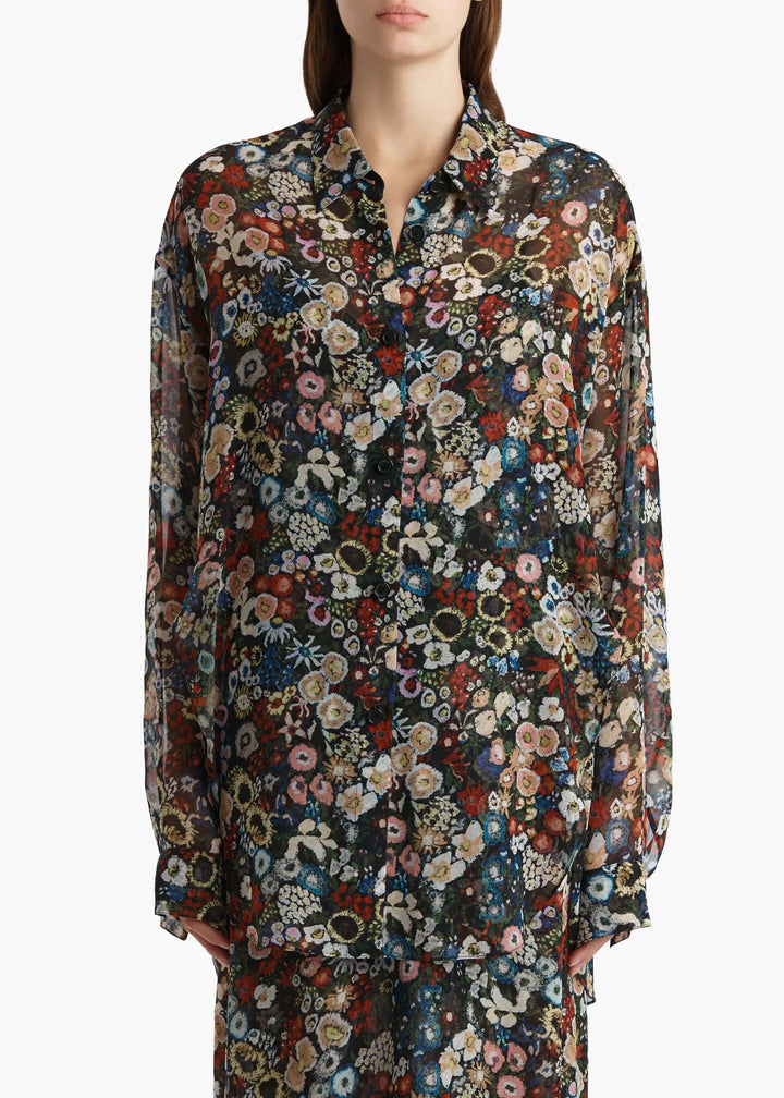 Multicolored floral patterned shirt worn by a person on a white background