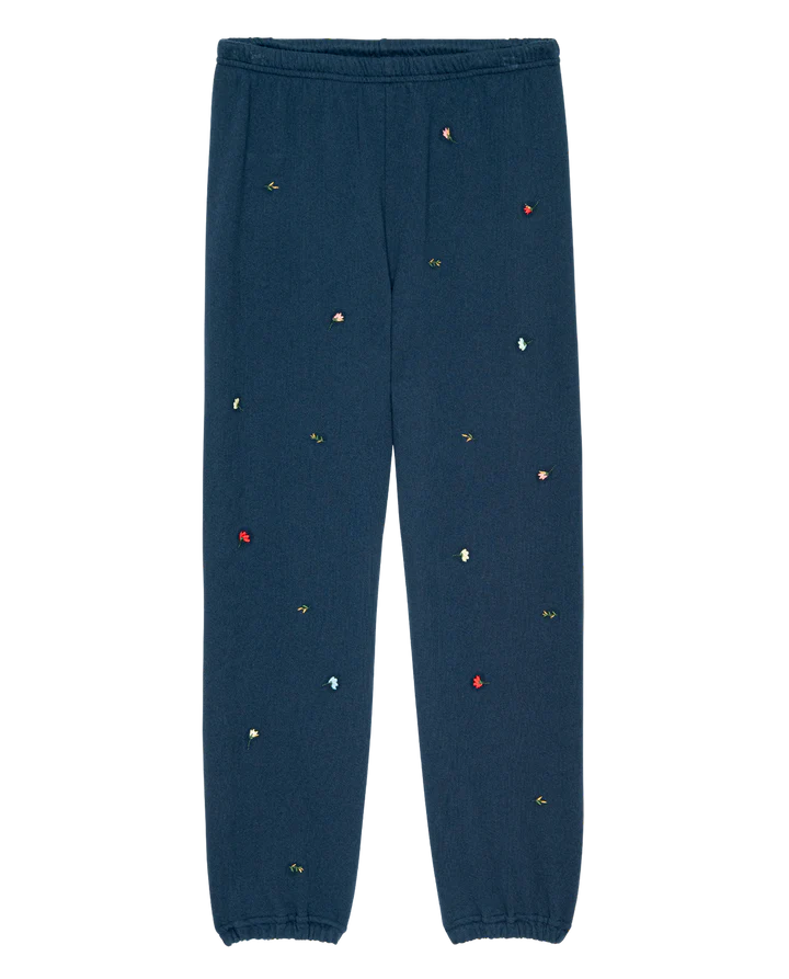 Navy blue pants with colorful embellishments on a white background