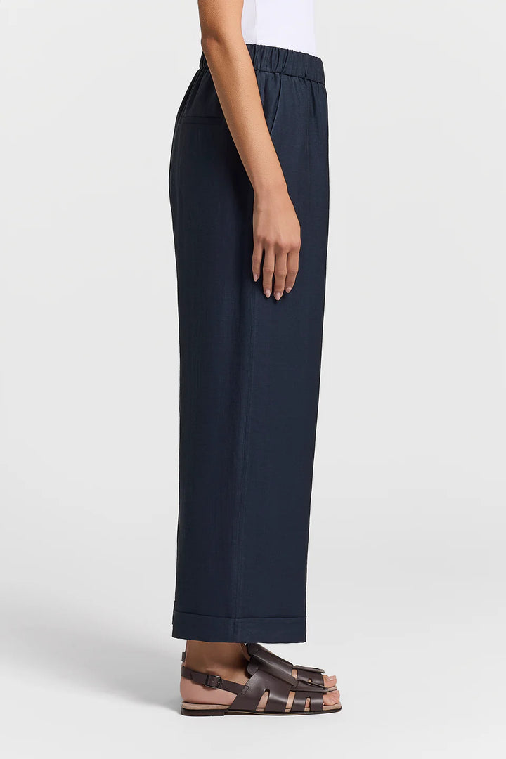 Navy blue pants worn by a person on a white background