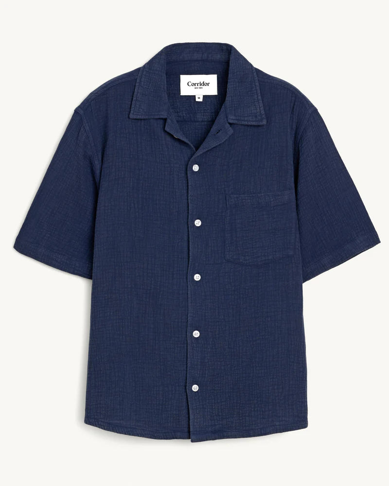 Navy blue short-sleeve shirt with button details on a white background