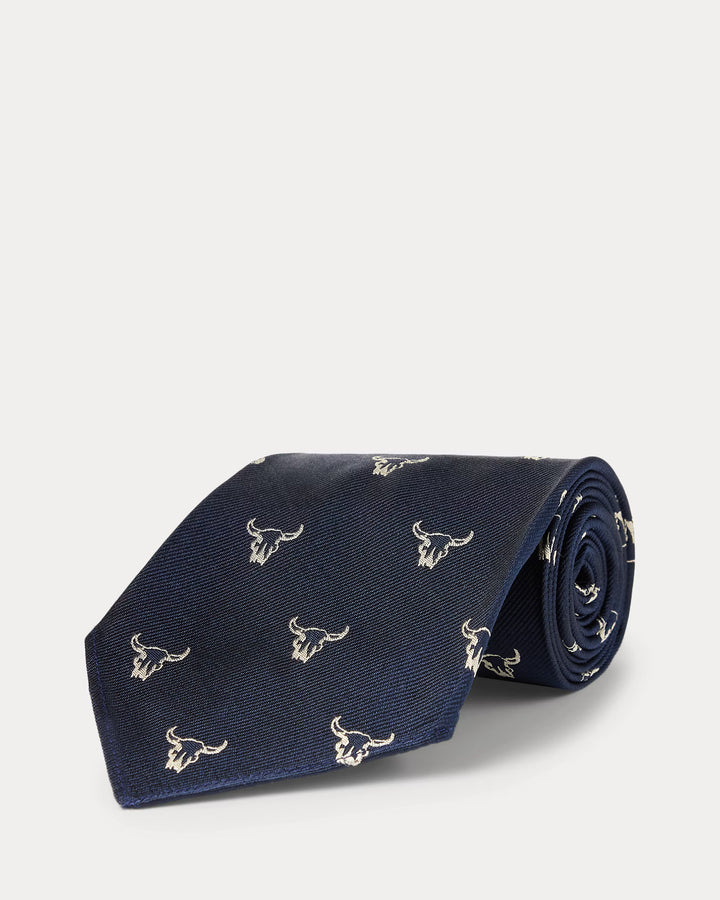 Navy blue tie with bull skull pattern on a light gray background