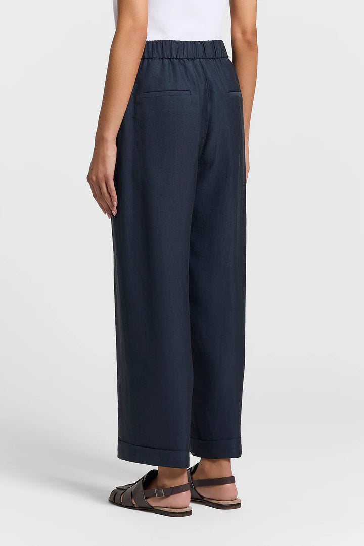 Navy pants worn by a person on a white background