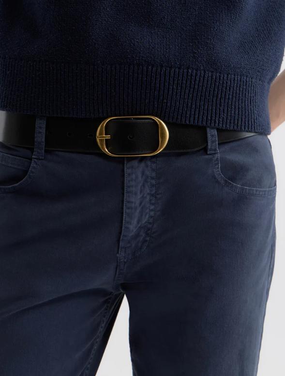 Navy sweater and pants with a black belt and gold buckle on a light gray background