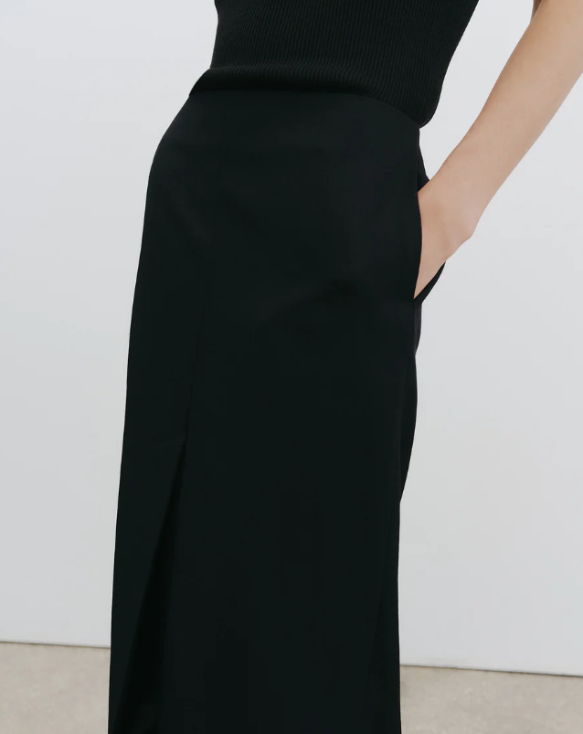 Black skirt worn by a person against a white background
