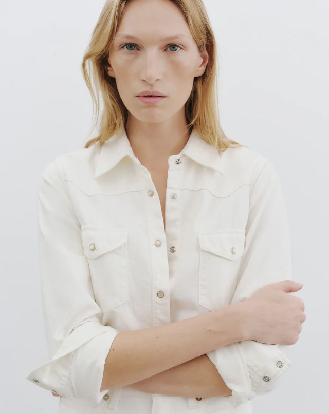 Person wearing a white shirt against a plain background