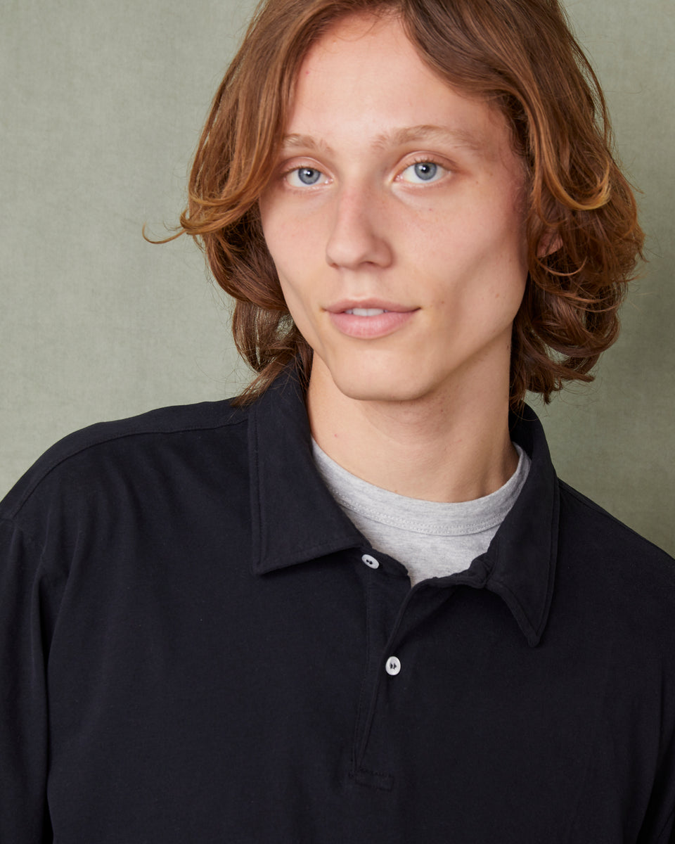 Person wearing a black shirt with a neutral background