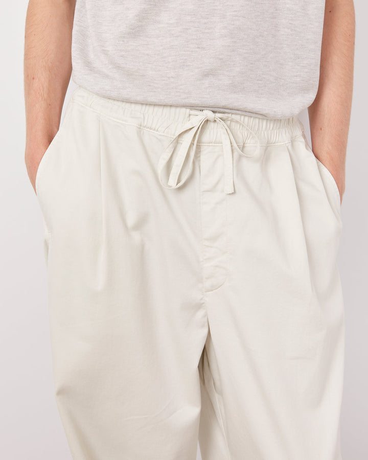 Beige pants worn by a person on a plain background