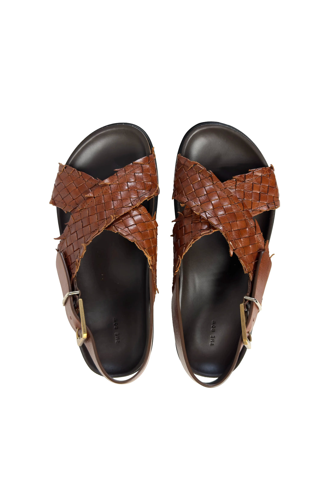 Pair of brown woven sandals on a white background