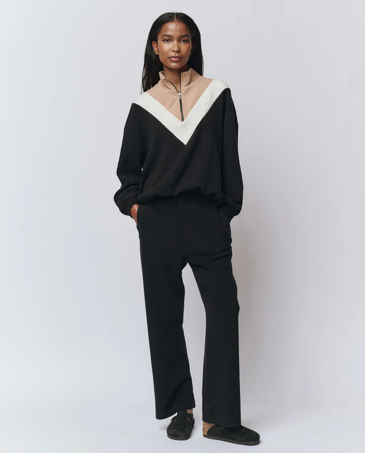 Person wearing a black and white outfit on a plain background