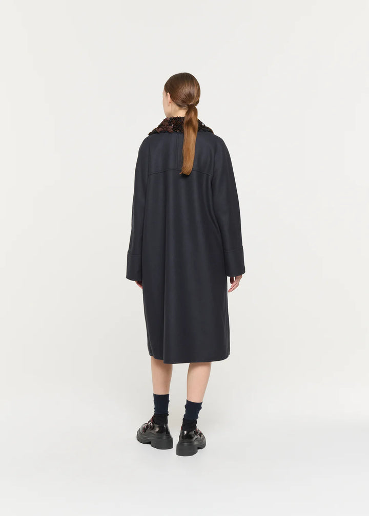 Person wearing a black coat on a white background