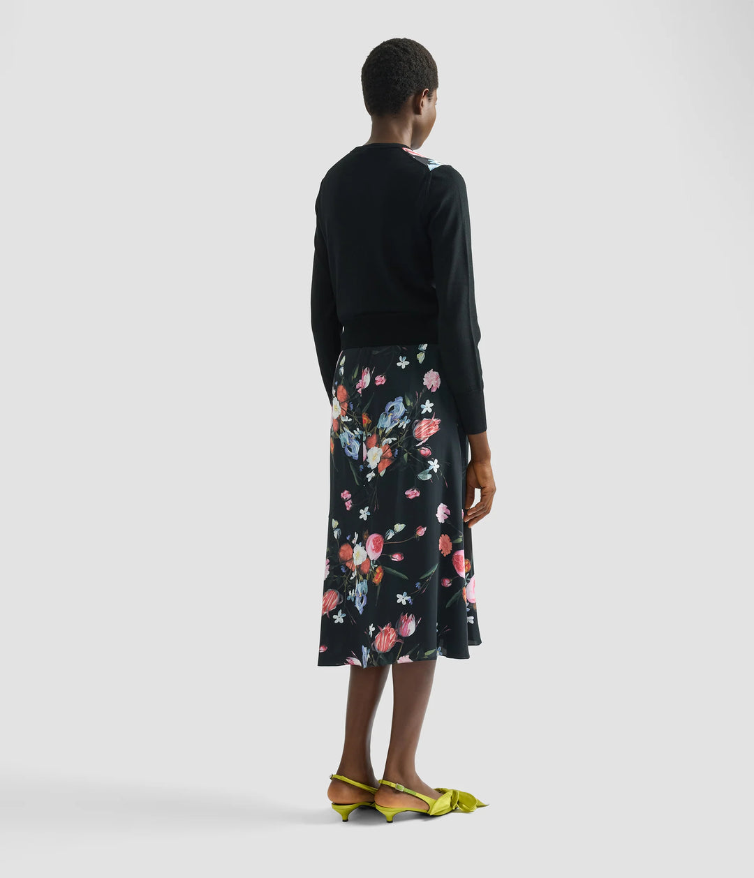 Person wearing a black floral skirt on a white background