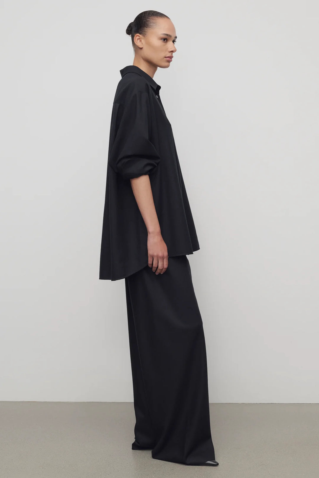 Person wearing a black outfit against a white background