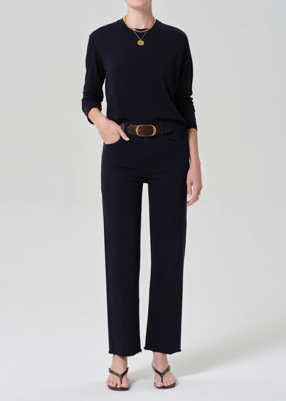 Person wearing a black outfit with a belt on a white background