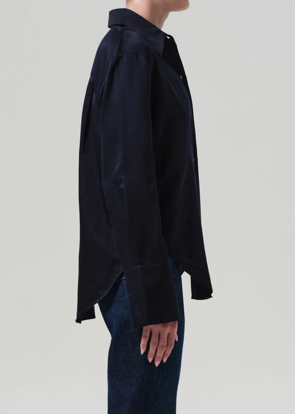 Person wearing a black shirt and jeans on a light gray background