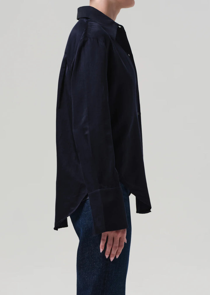 Person wearing a black shirt and jeans on a light gray background