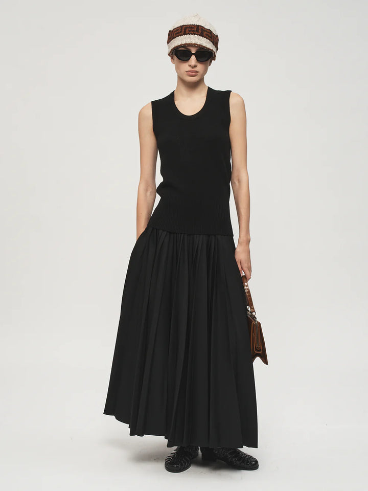 Person wearing a black sleeveless dress with a white background