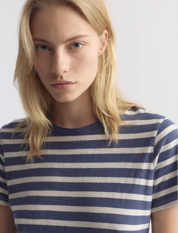 Person wearing a blue and white striped shirt against a plain background