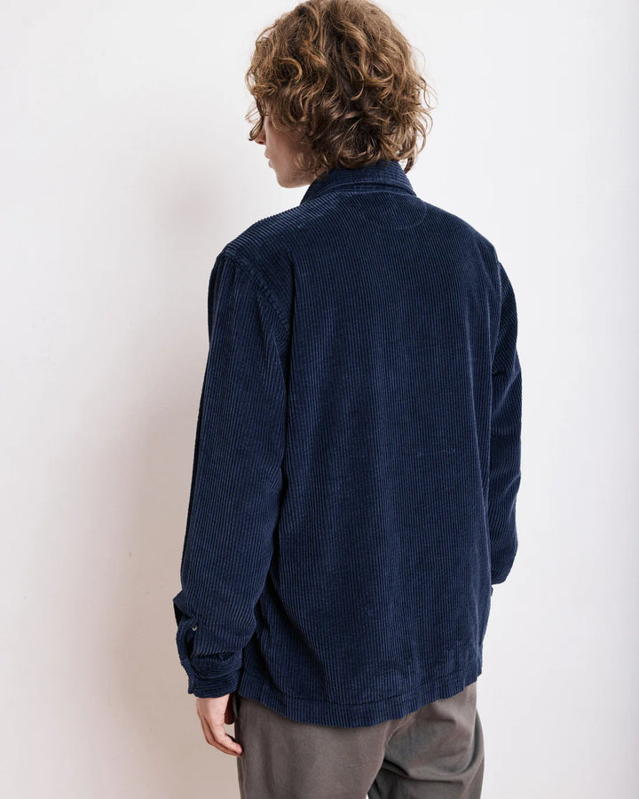 Person wearing a blue corduroy shirt against a white background