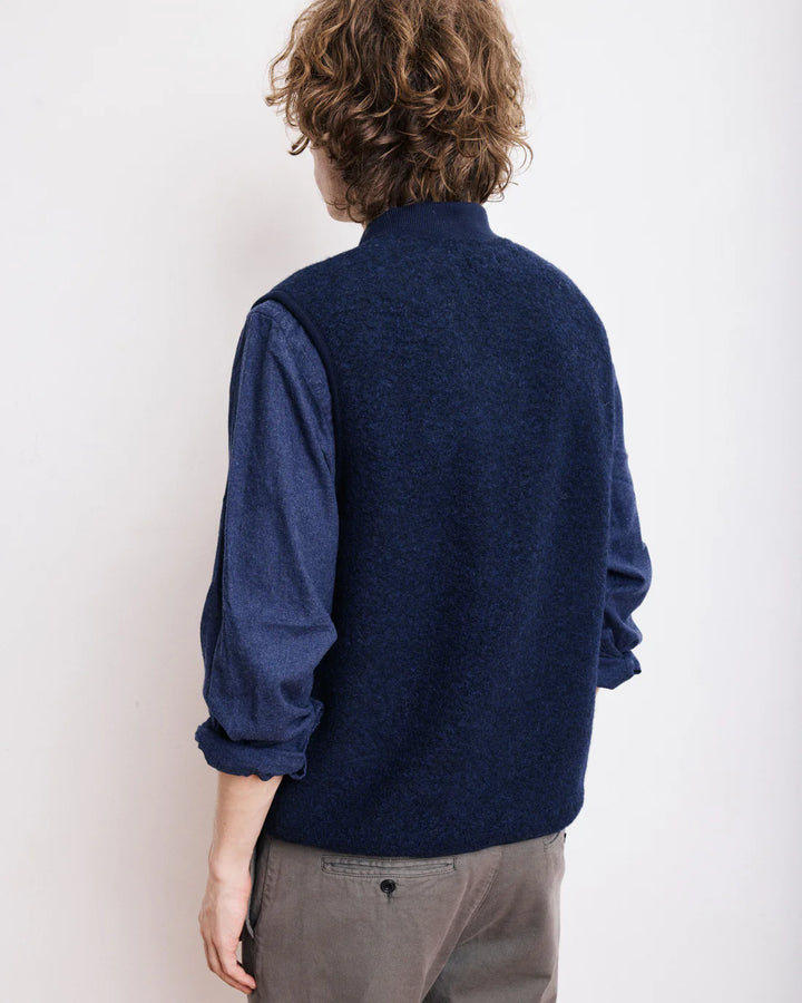 Person wearing a blue sweater against a white background