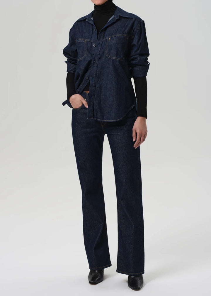 Person wearing a dark denim outfit on a white background