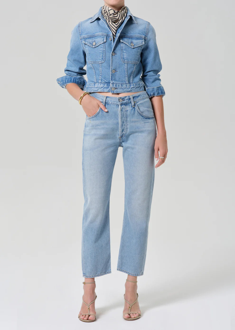 Person wearing a denim jacket and jeans on a white background