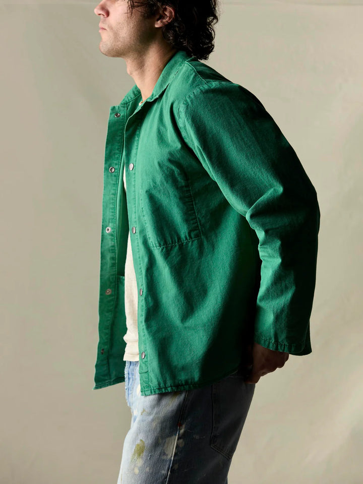 Person wearing a green jacket against a plain background