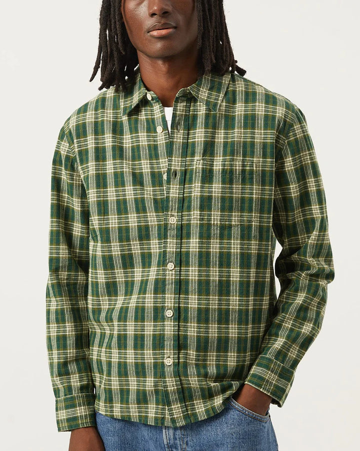 Person wearing a green plaid shirt against a plain background