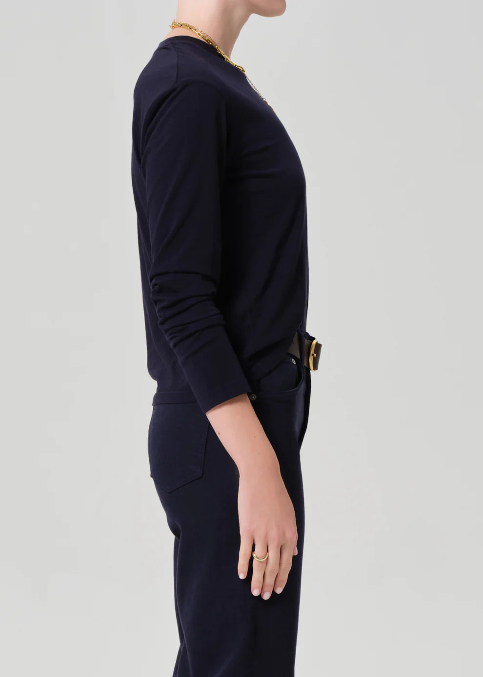 Person wearing a navy blue outfit with a light gray background