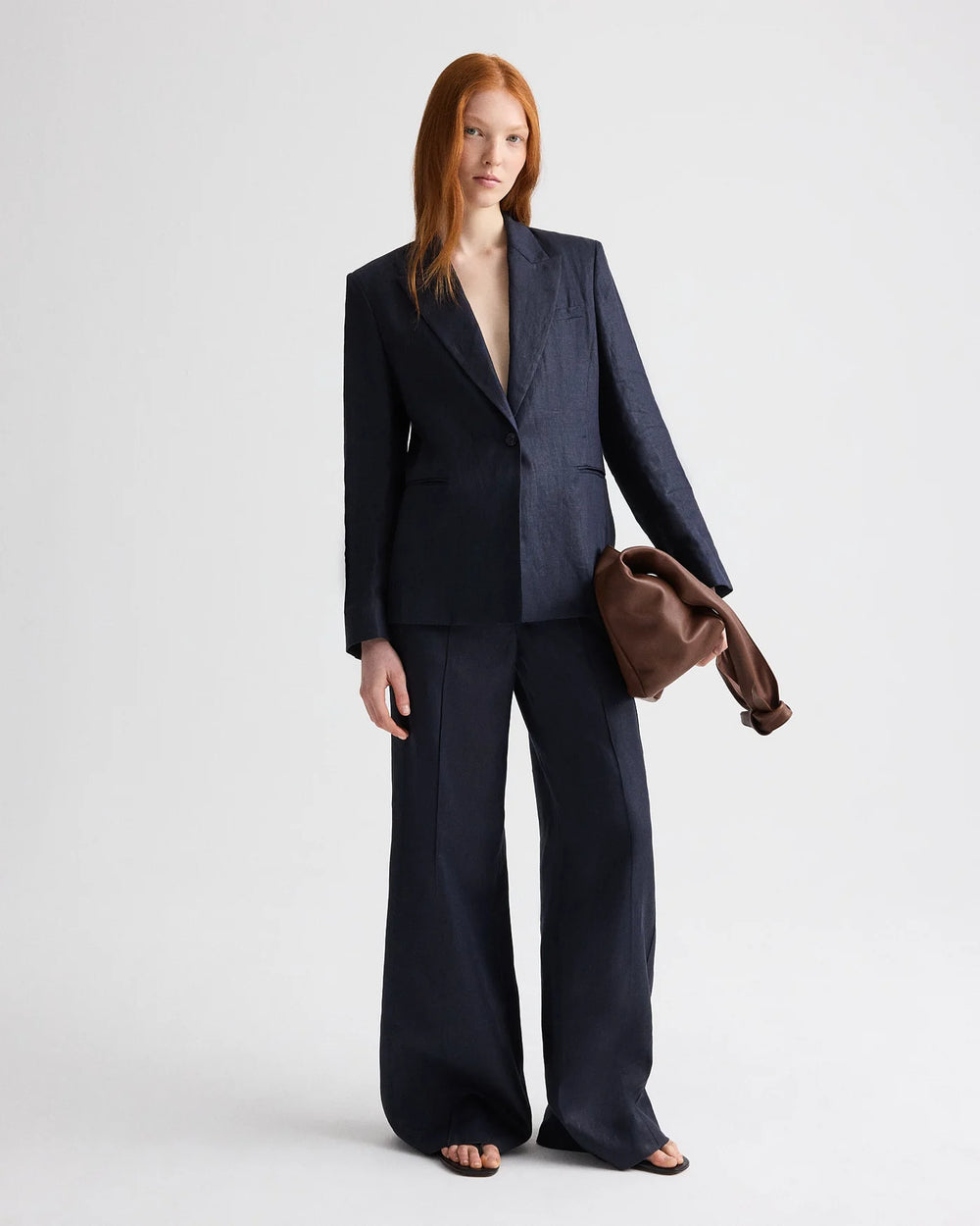 Person wearing a navy suit with a plain background