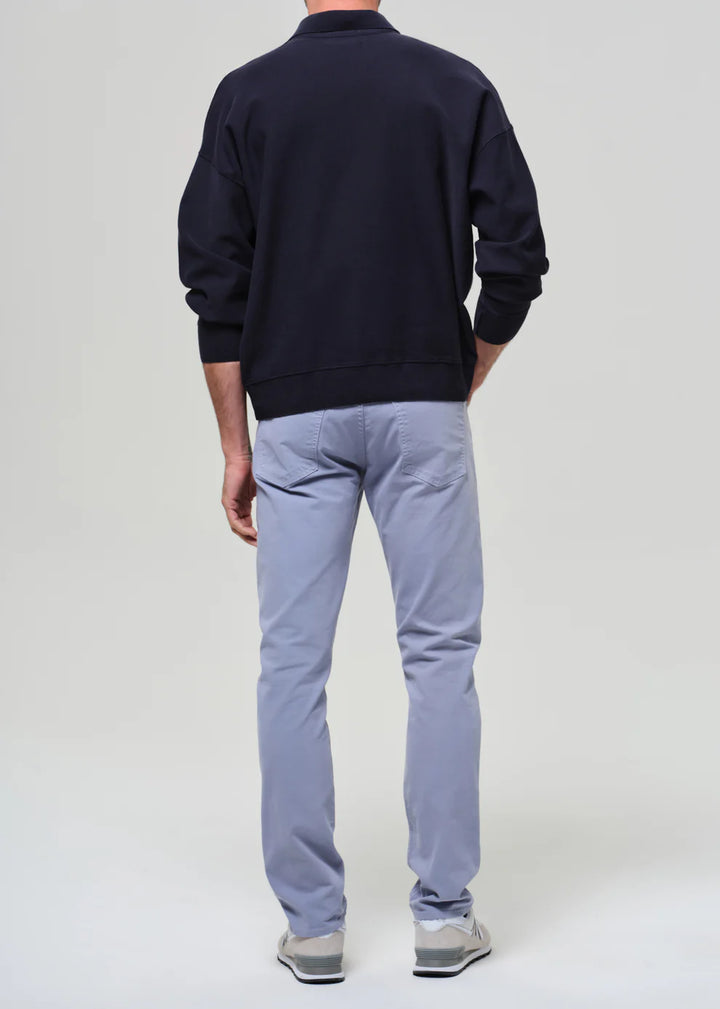 Person wearing a navy sweatshirt and light blue pants on a white background