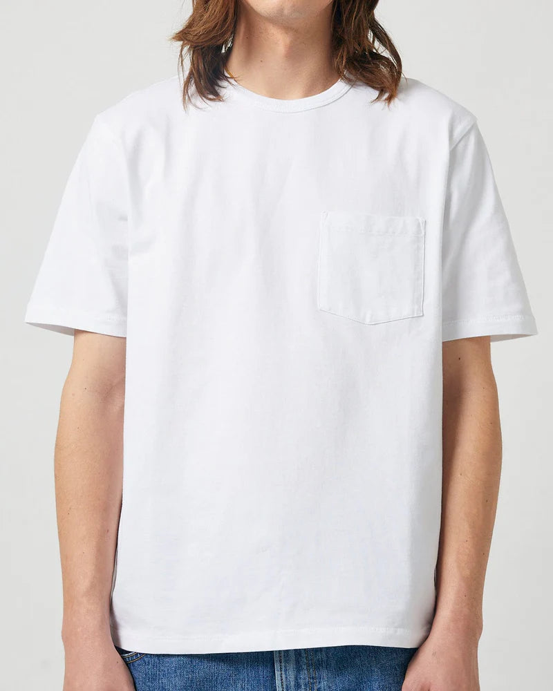 Person wearing a plain white t-shirt on a light gray background