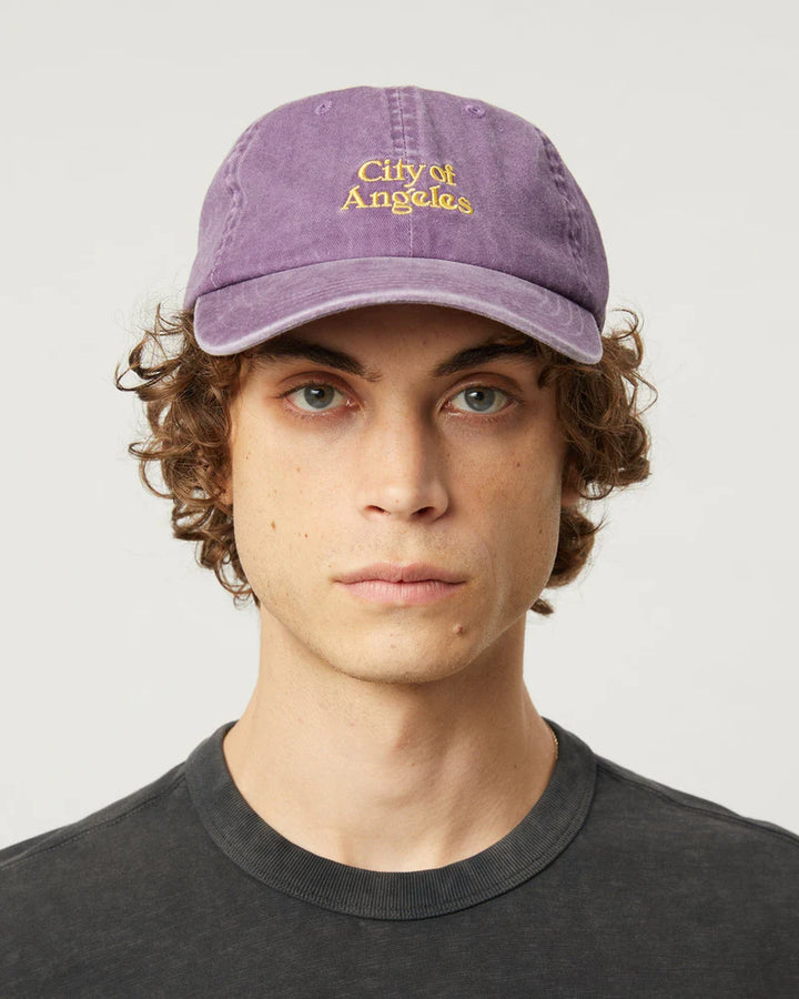 Person wearing a purple 'City of Angeles' cap against a plain background