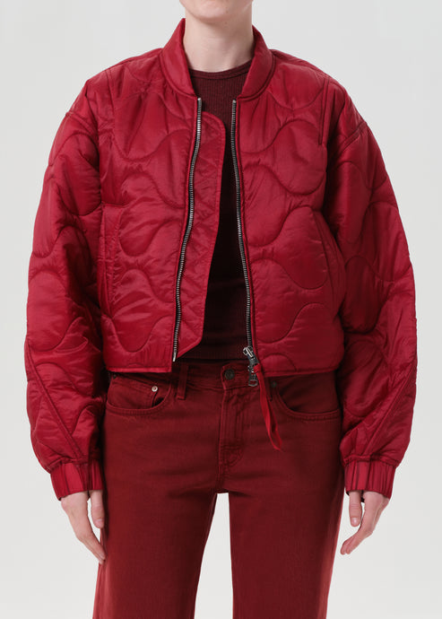 Person wearing a red quilted jacket and pants on a white background