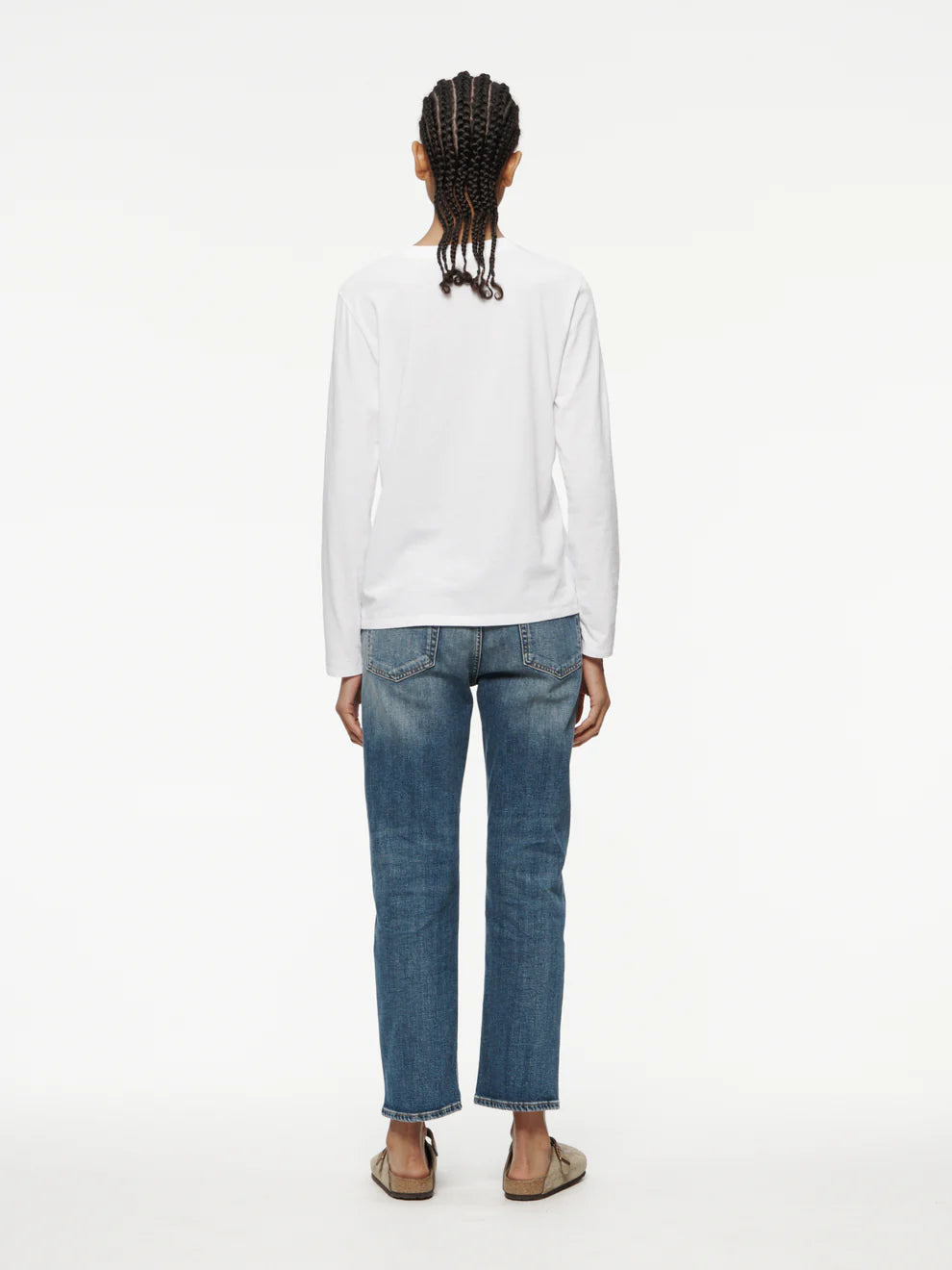 Person wearing a white hoodie and blue jeans on a white background