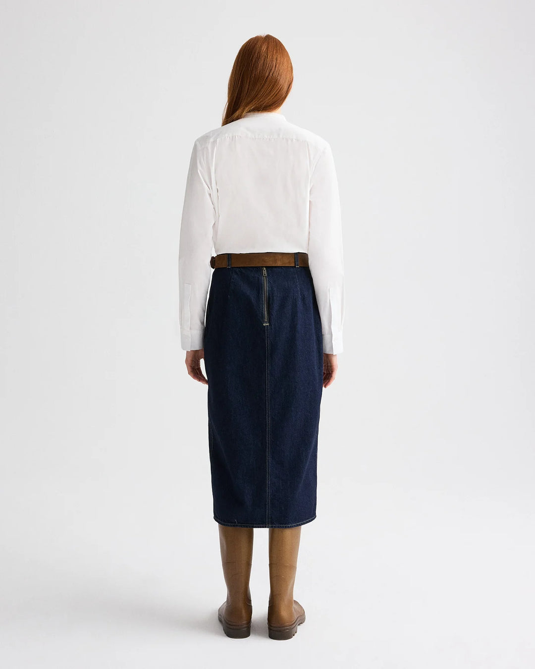 Person wearing a white shirt and navy skirt on a white background