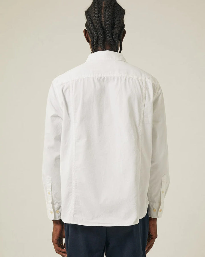 Person wearing a white shirt with a neutral background