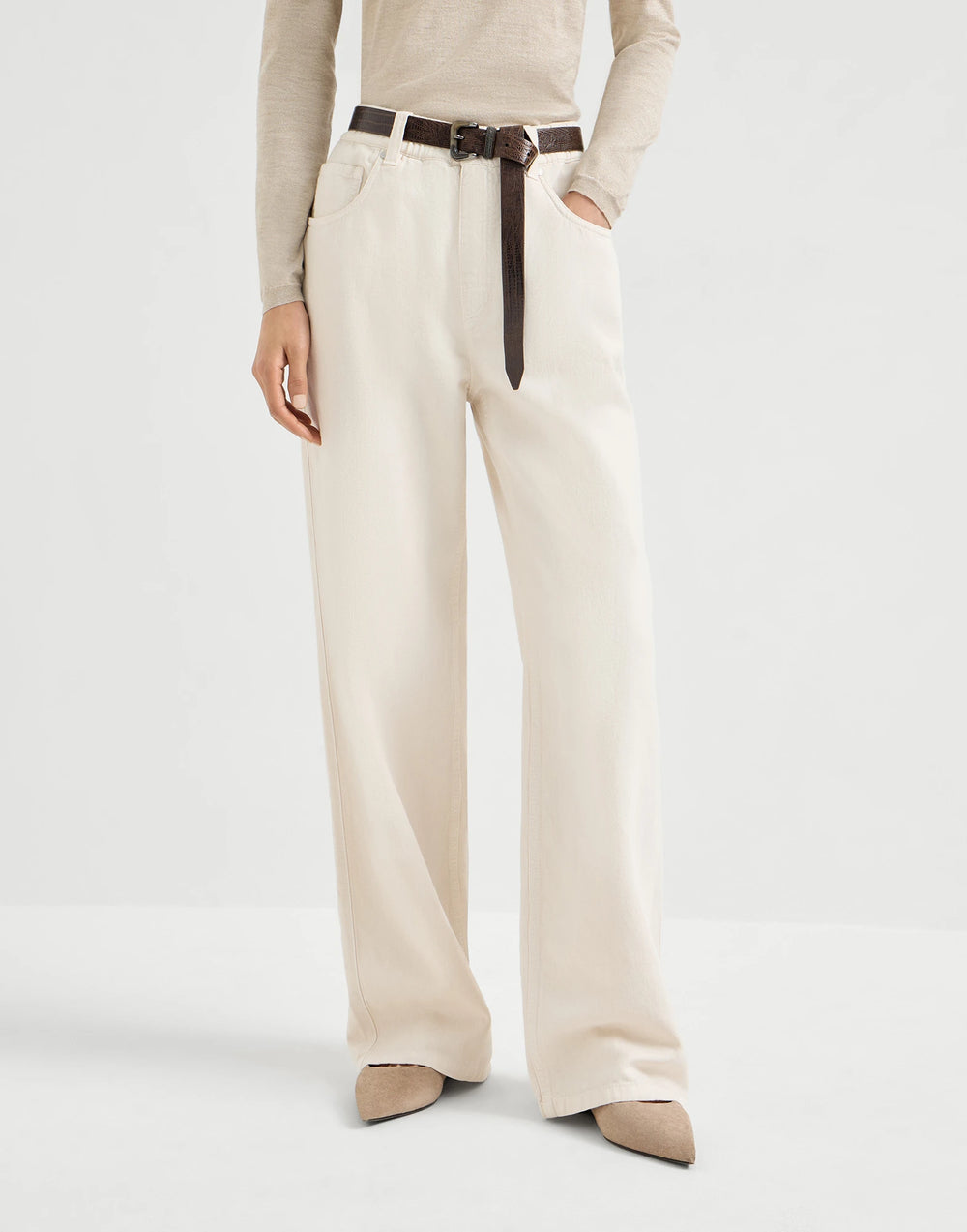 Person wearing beige wide-leg pants with a belt on a white background