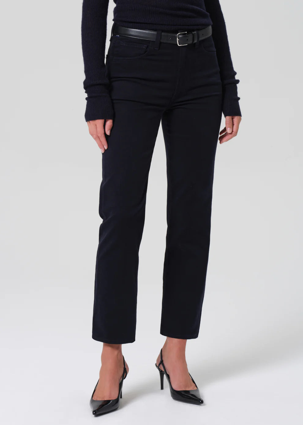 Person wearing black pants and a black top on a white background