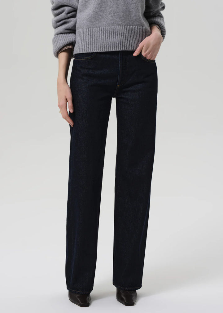 Person wearing black pants and a gray sweater on a white background