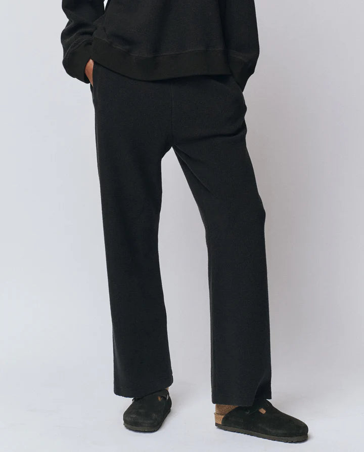 Person wearing black pants and shoes on a white background