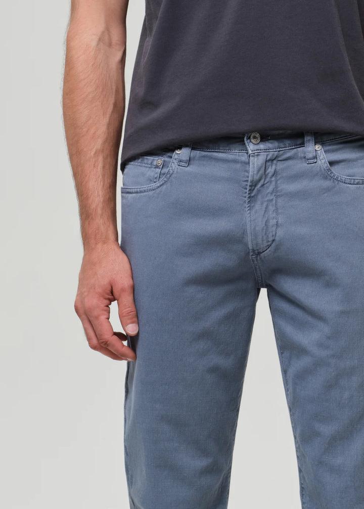Person wearing blue jeans and a dark shirt on a plain background