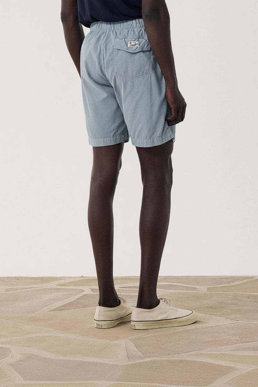 Person wearing blue shorts on a plain background