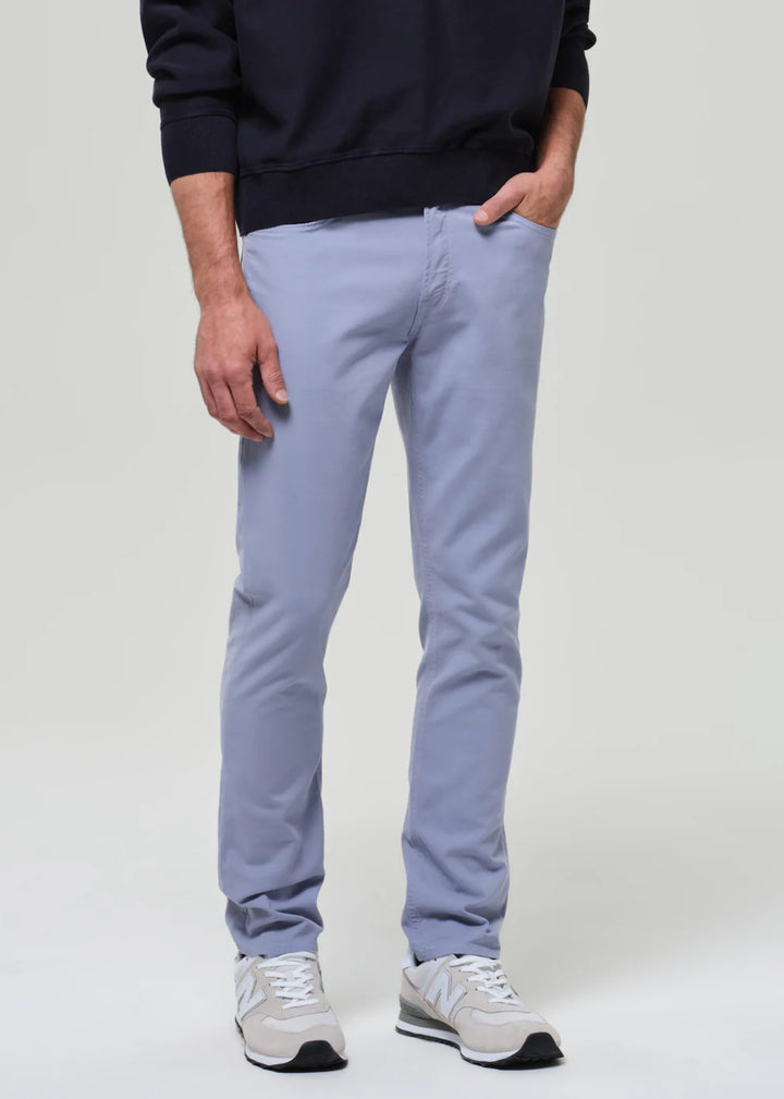 Person wearing light blue pants and a dark sweater on a white background
