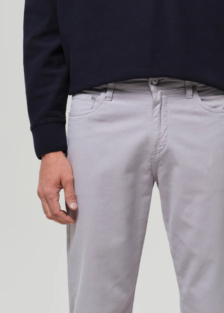Person wearing light gray pants and a navy sweater on a plain background