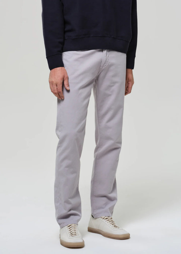 Person wearing light gray pants and a navy sweater on a white background