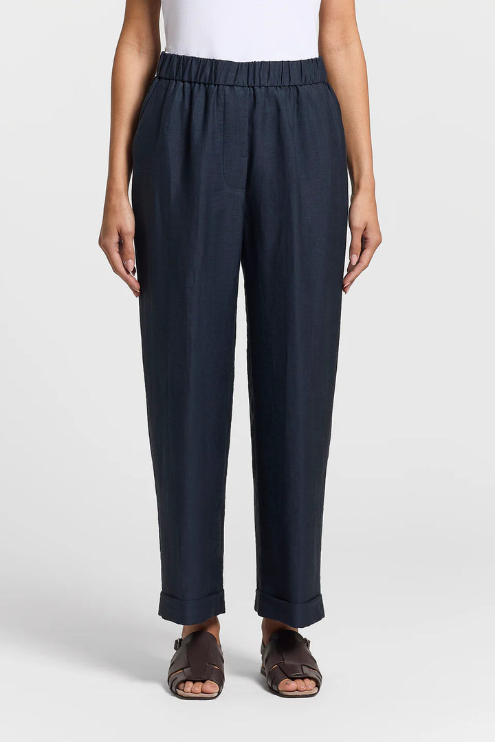 Person wearing navy pants on a white background