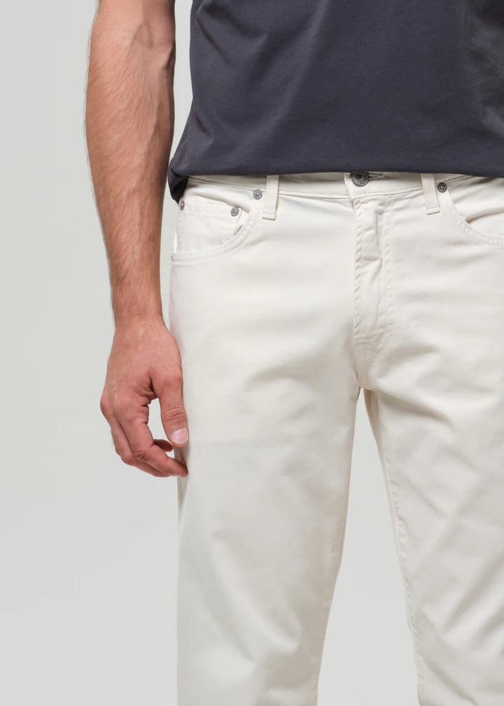 Person wearing white pants and a navy shirt on a plain background